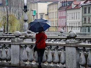 Ljubljana dež ženska z dežnikom stoji na mostu
