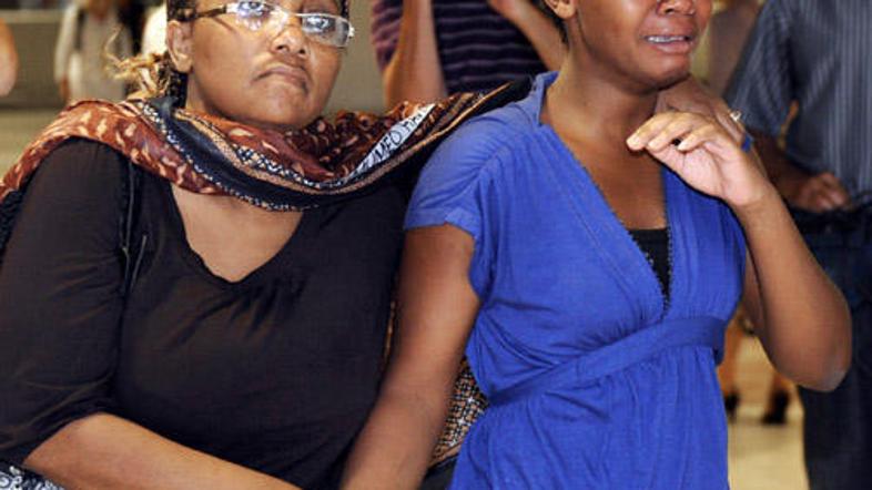 Svojci žalujejo za umrlimi na letalu.