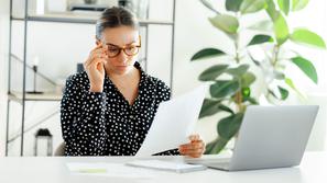 ženska v pisarni bere dokument