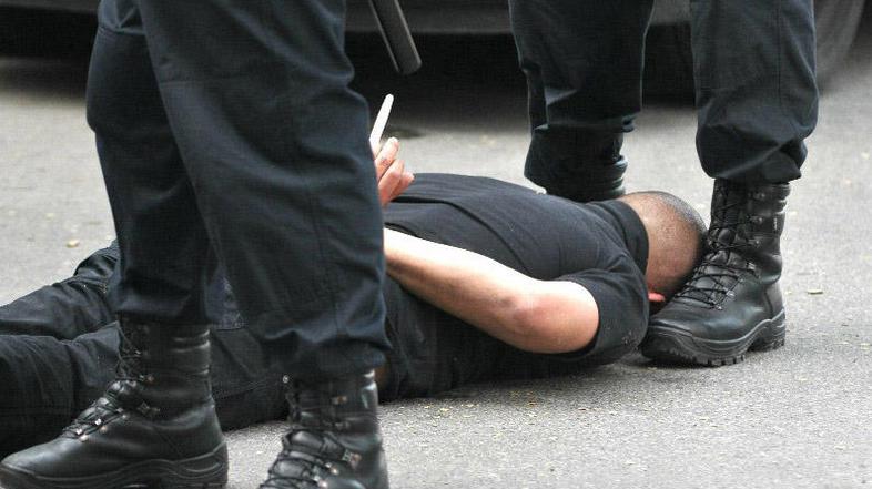 Osumljenec je moral z obrazom navzdol med nogami policista počakati na preiskavo