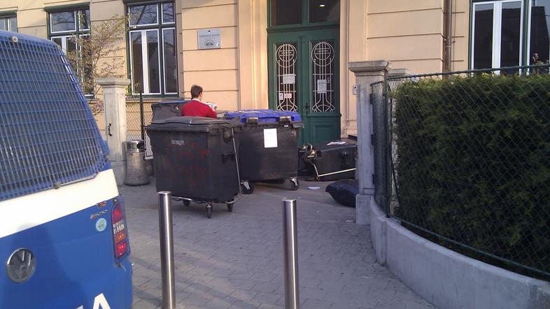 Vandali so poškodovali stavbo in videonadzor, pred vrata navlekli smetnjake in v