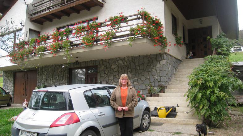 Marija Cener pred hišo, ki jo bo morala zapustiti, razmišlja, da bi bilo bolje z