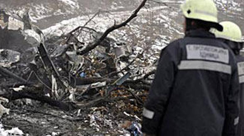 Gasilci preiskujejo razbitine helikopterja.