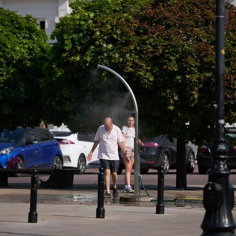 moški se hladi pod vodno meglica vročinski val na Poljskem
