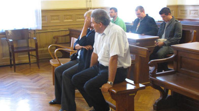 Darinka si je pred mediji zakrivala obraz. Janez je nepremično strmel predse.