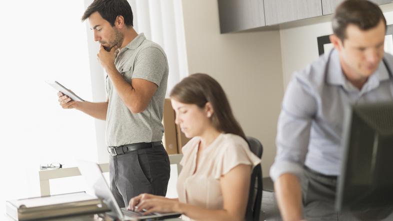 Dva moška in ženska v pisarni delajo