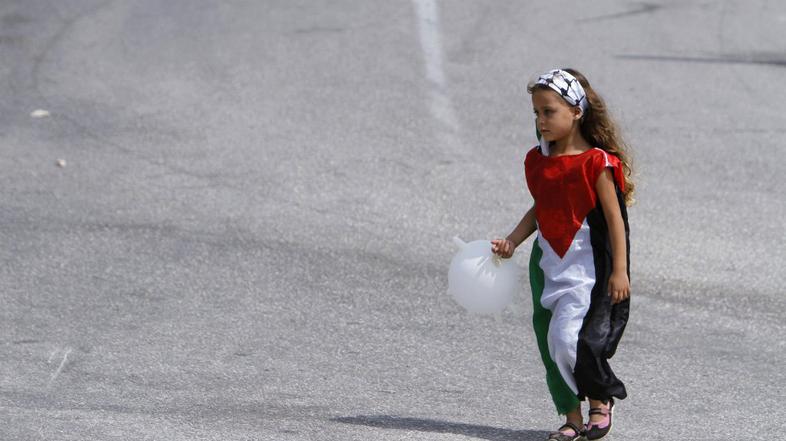 Deklica, oblečena v palestinsko zastavo.