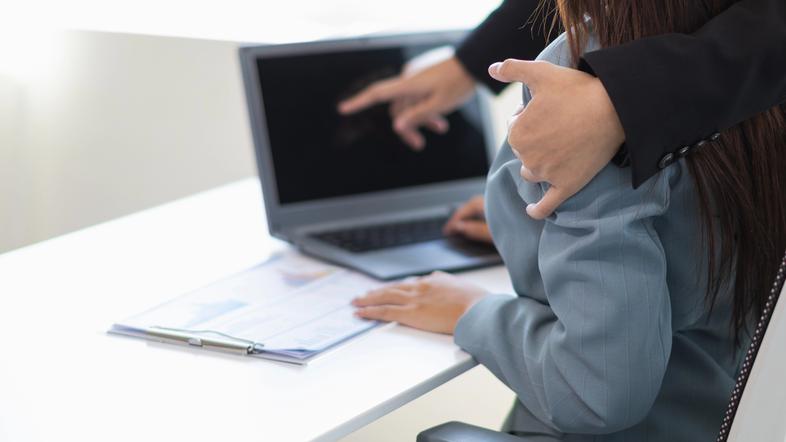 Moški se dotika ženske v službi