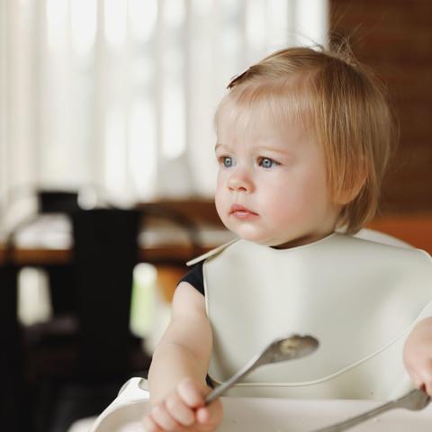 deklica sedi v stolčku za hranjenje