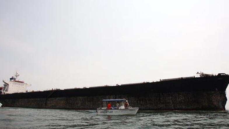 Več deset malezijskih gasilcev se je borilo z ognjem, ki je po trčenju s tovorno