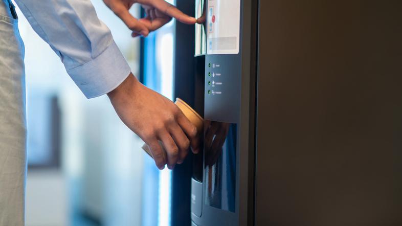 Priprava kave na avtomatu v pisarni