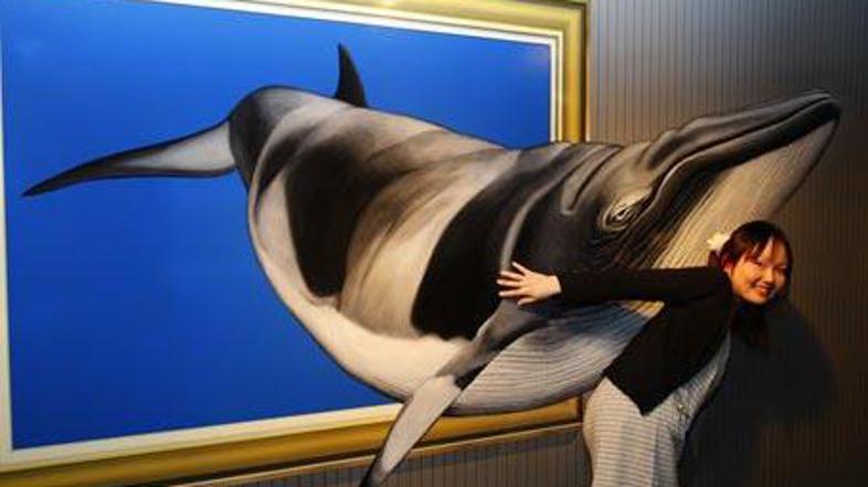 Obiskovalka muzeja pozira pred zanimivo sliko.