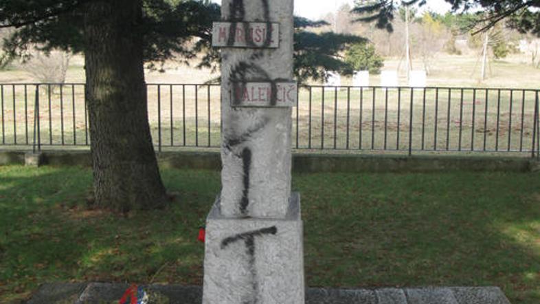 Neznanci so na spomenik napisali besedi banditi in porci.