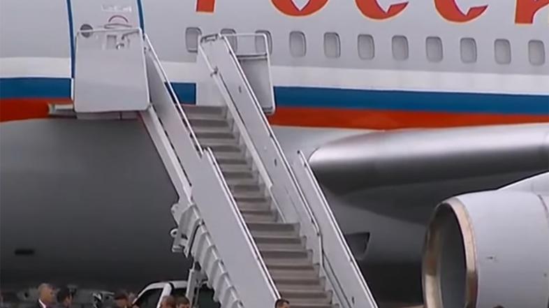 Ameriški vojaki klečijo, da bi razvili rdečo preprogo za ruskega predsednika Vladimirja Putina