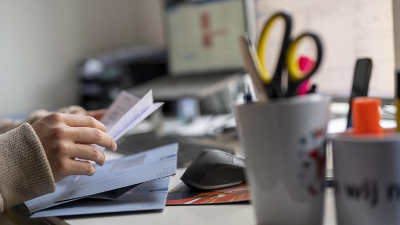 oseba ureja dokumente na mizi