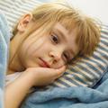 utrujena deklica leži na postelji