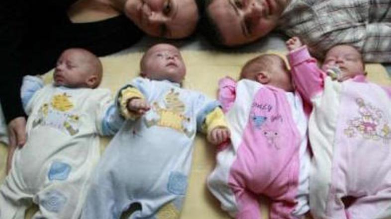 Ponosna starša z identičnimi četvorčki.