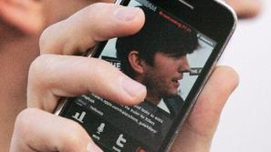 Igralec Ashton Kutcher svoj iphone razkazuje tudi na javnih prireditvah. (Foto: 