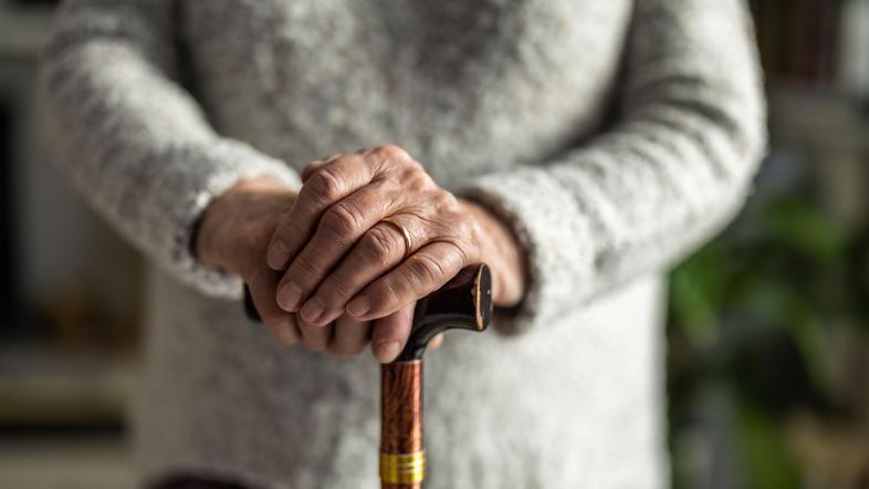 starejša ženska s palico v roki