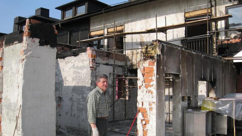 Gospodar Otto Sevšek ob pogorišču gostilne, pod tujskimi sobami, ki jih je tudi 