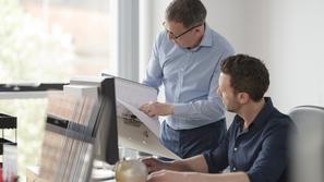 Sodelavca moška v pisarni se pogovarjata