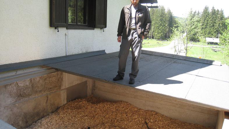 Revirni gozdar Alojz Budkovič na zalogovniku za lesne sekance, s katerimi ogreva