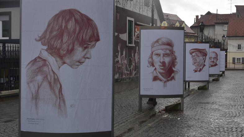 Razstava slovenskih velikanov na velikih plakatih pred mestno knjižnico.