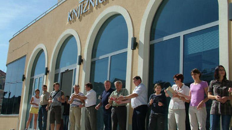 Številni prostovoljci, povezani v živo verigo, so na pobudo občine do polic poma