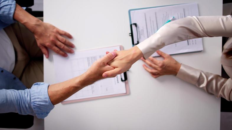 dve osebi sta si segli v roke rokovanje