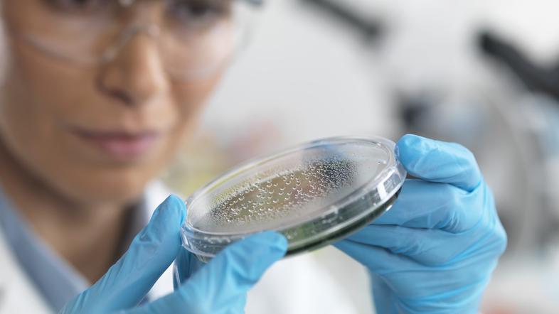 Znanstvenica v laboratoriju - raziskuje mikrodelce