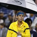 Rafael Nadal je pod varnim zavetjem dežnika po uri in pol zapustil stadion Arthu