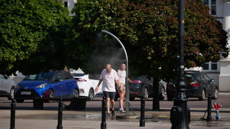 moški se hladi pod vodno meglica vročinski val na Poljskem