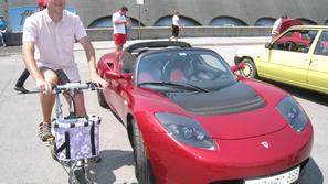 Vozilo tesla roadster sport in električno kolo sta na postanku zelene karavane n