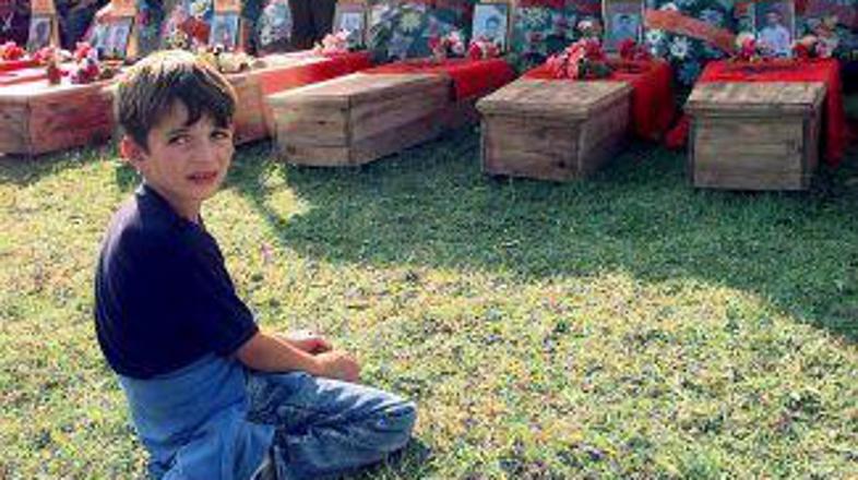 Kosovski deček ob krsti svojega očeta, ki so ga Srbi ubili leta 1999.