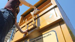 Komunala oblačila iz rumenega zabojnika preda podjetju, ki se ukvarja s humanita