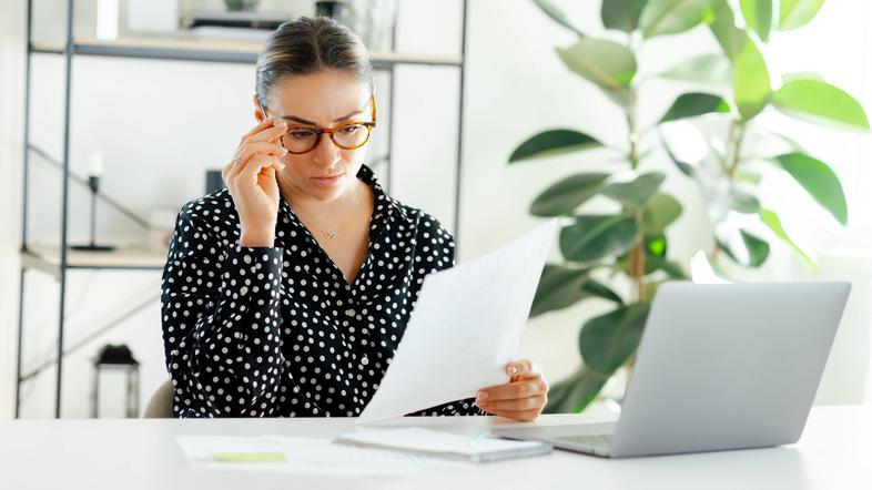 ženska v pisarni bere dokument