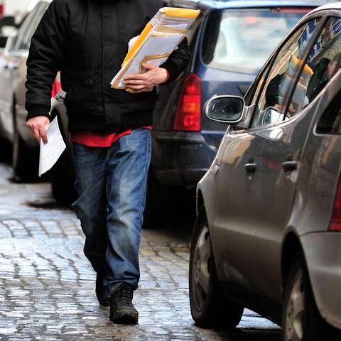 Moški s paketom hodi po ulici