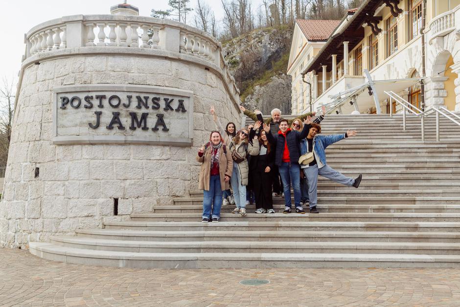 Skupina ljudi pred postojnsko jamo - workation | Avtor: Aleksandar Domitrica