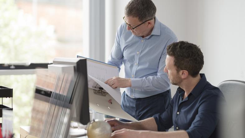 Sodelavca moška v pisarni se pogovarjata