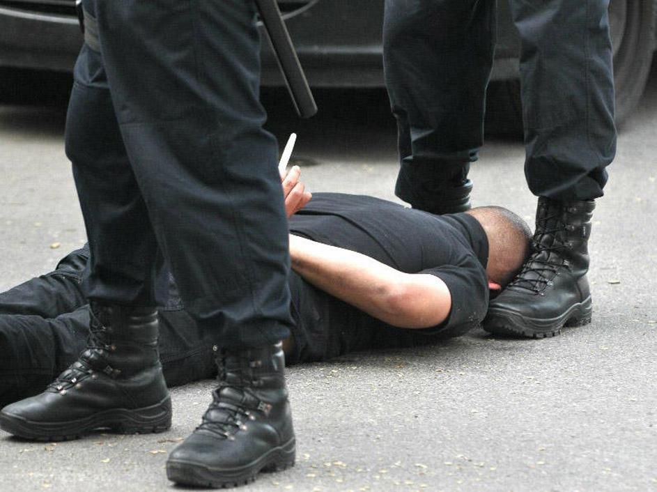 Osumljenec je moral z obrazom navzdol med nogami policista počakati na preiskavo