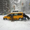 mimoidoči pomagajo rešiti avtomobil, ujet v snegu na ulicah New Yorka