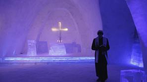 Duhovnik se sprehaja po novi cerkvi iz snega in ledu.