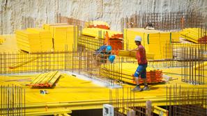 Gradbeni delavci med delom na žgočem soncu.