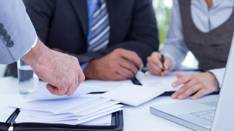 Sodelavci moški in ženska za mizo delajo