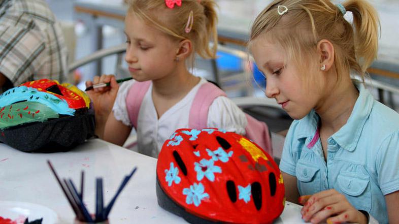 Otroci so si lahko v ustvarjalni delavnici poslikali čelade po svojem okusu. (Fo