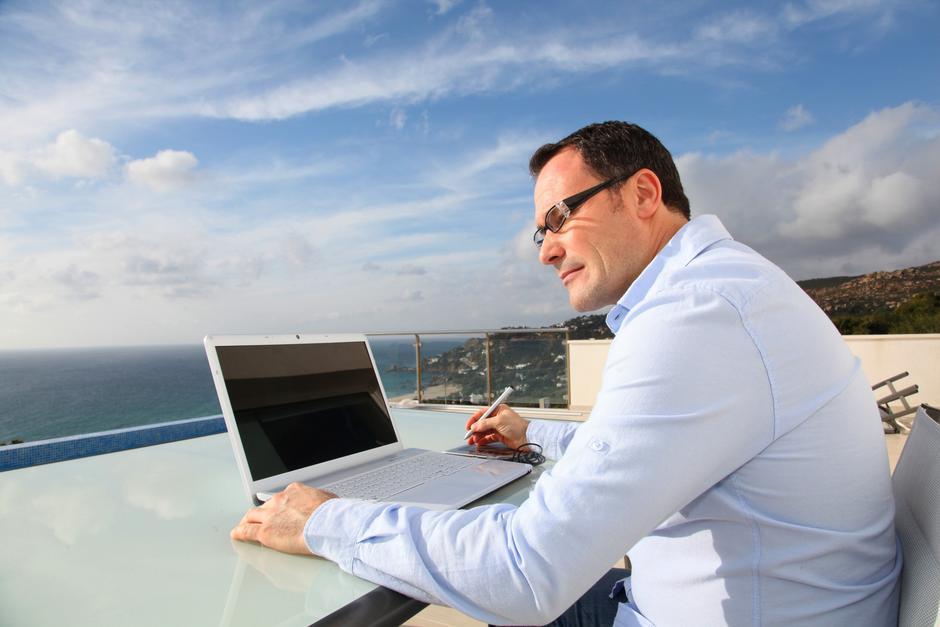 Moški na računalniku ob morju | Avtor: Profimedia