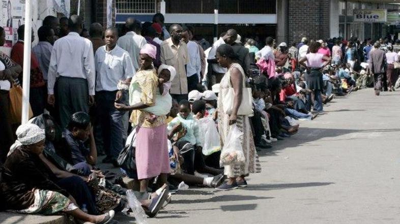 Pred banko se vije dolga vrsta ljudi, ki želijo zaradi rekordne inflacije dvigni