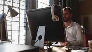 Moški sedi za računalnikom