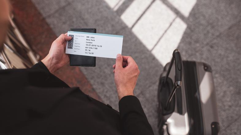 moški drži v rokah letalsko karto
