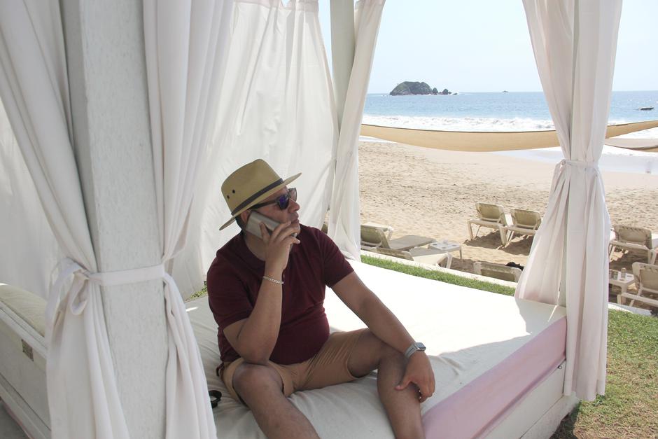 Moški telefonira na plaži s pogledom na morje | Avtor: Profimedia